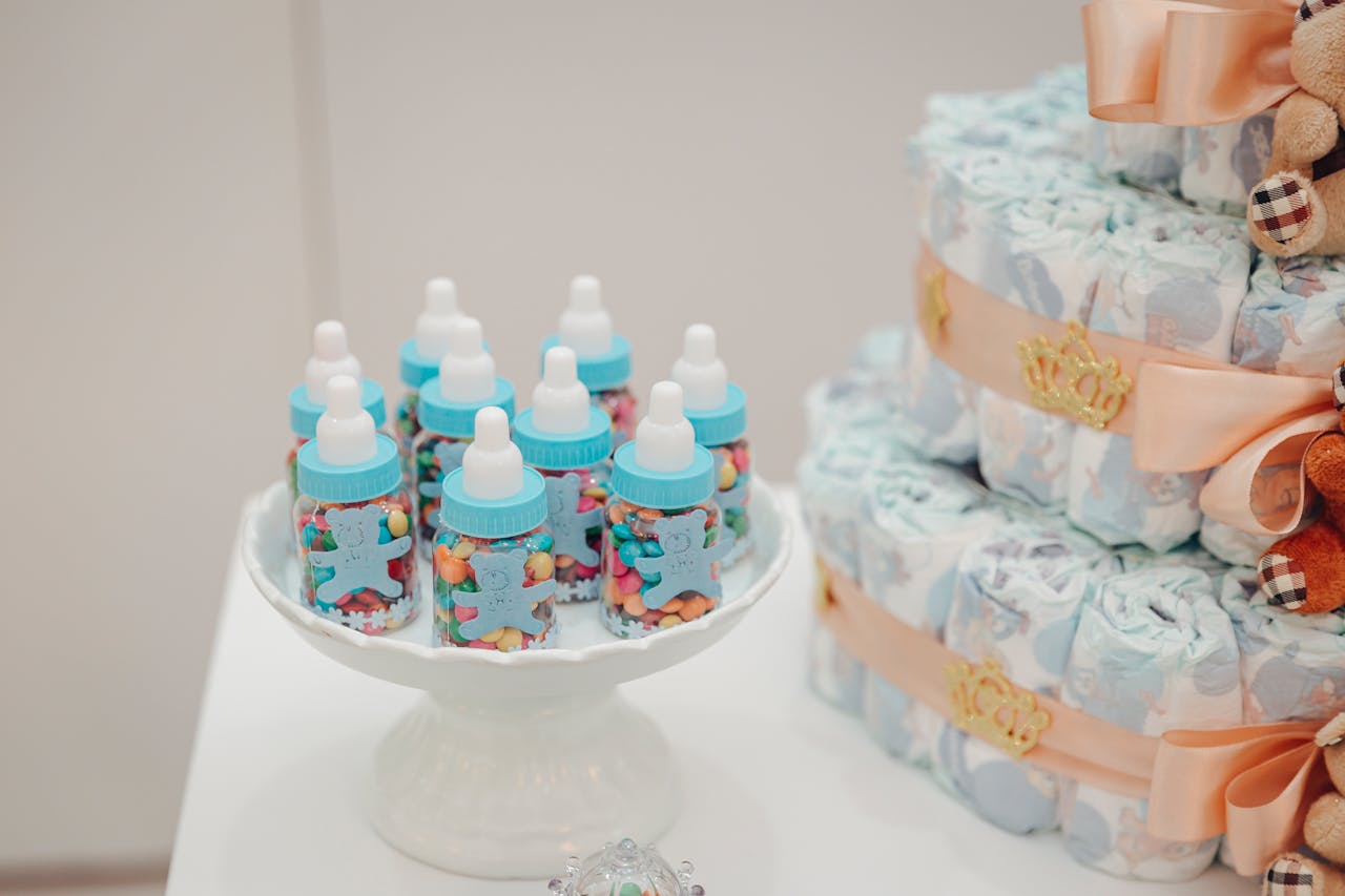 Colorful candies in baby bottles and a decorated diaper cake for a baby shower.