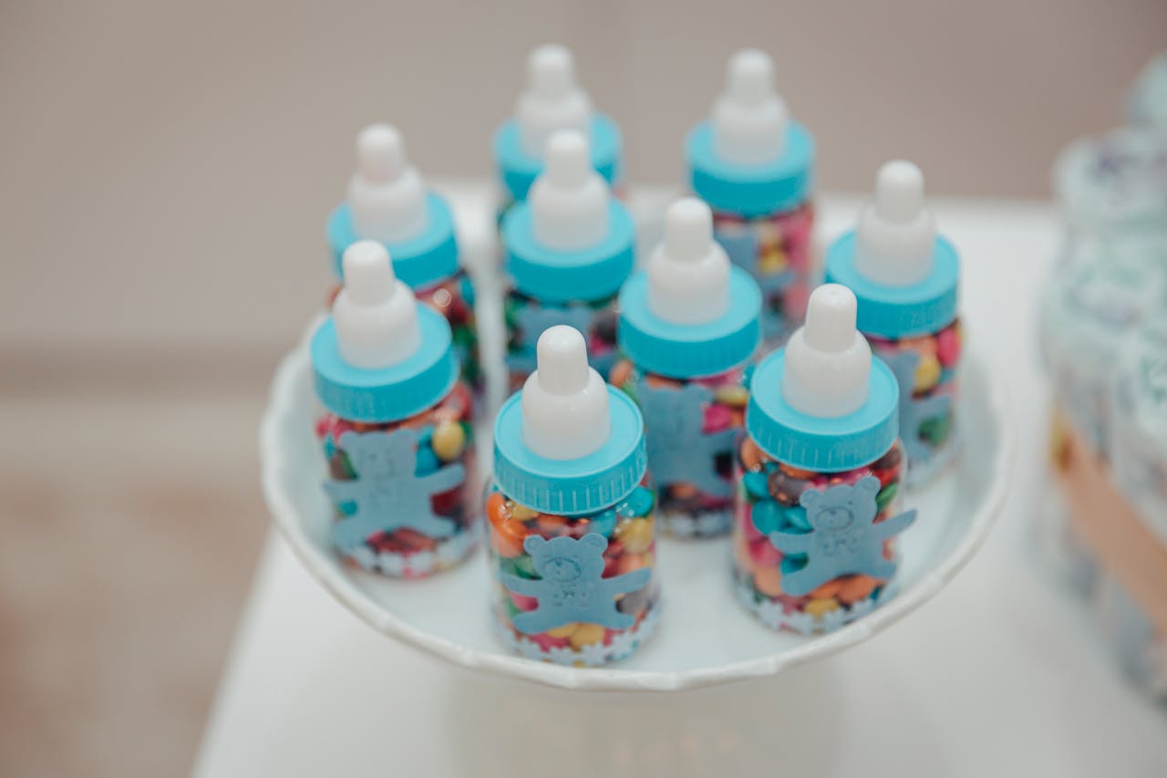 Baby shower candy favors in feeding bottle shape, colorful and fun display.