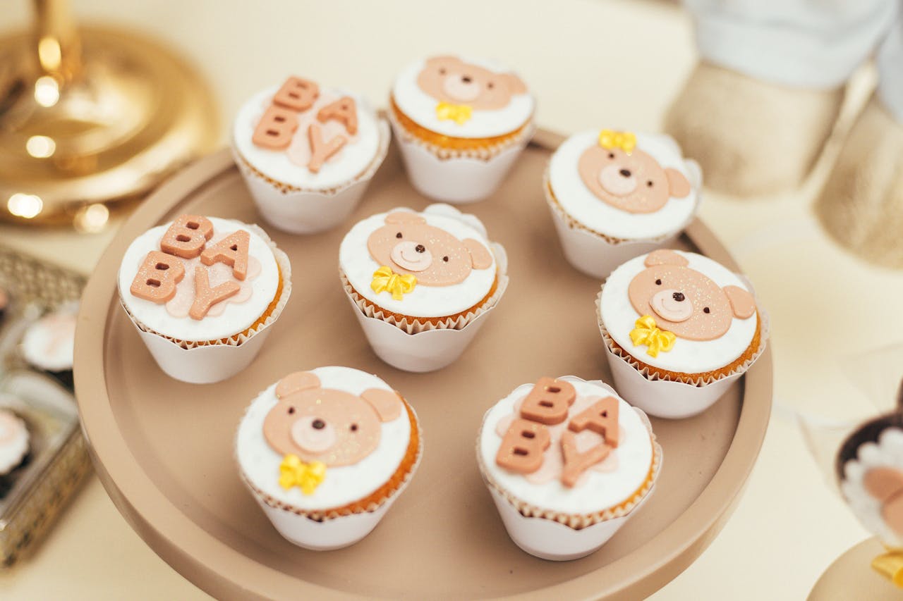Cute baby shower cupcakes featuring bear decorations and BABY lettering on a stylish tray.
