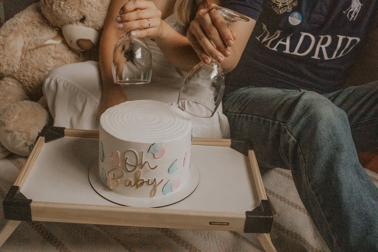 Celebrate a cozy baby shower with a decorative cake and glasses in a warm indoor setting.