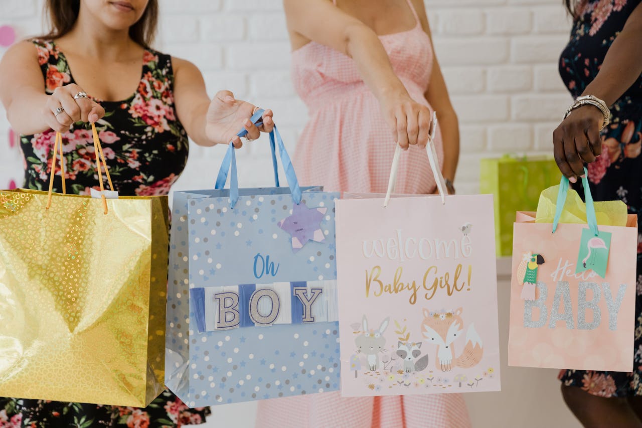 Women holding various colorful baby shower gift bags, perfect for joyful and festive occasions.